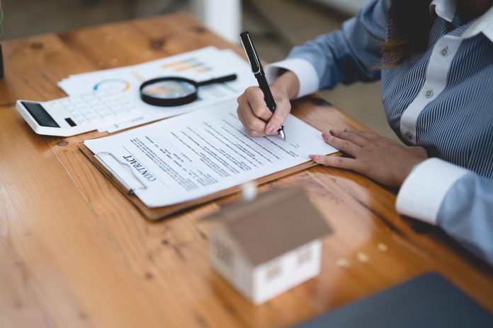 Woman signing rental contract at meeting with realtor or landlord, Property purchase, mortgage and loan ownership concept