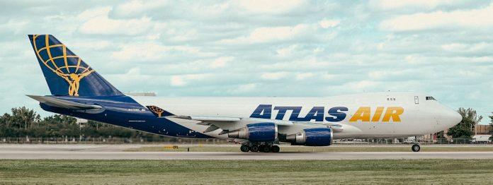 Cargo aircraft being loaded with freight containers at international airport facility