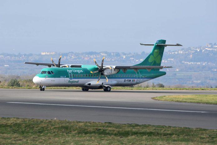 Passengers at Dublin Airport departure terminal preparing for summer holiday travel with luggage and boarding passes